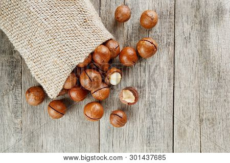 Macadamia Nut On A Wooden Table In A Bag, Closeup, Top View