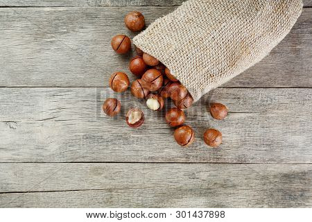 Macadamia Nut On A Wooden Table In A Bag, Closeup, Top View