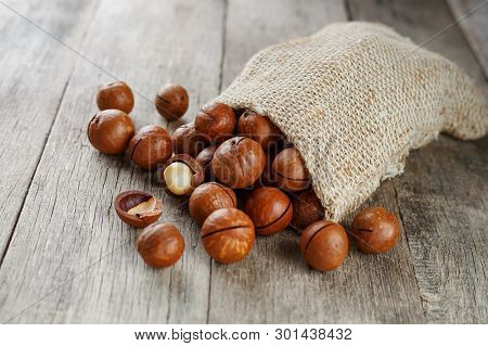 Macadamia Nut On A Wooden Table In A Bag, Closeup, Top View