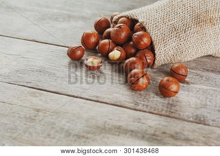 Macadamia Nut On A Wooden Table In A Bag, Closeup, Top View