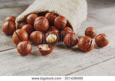 Macadamia Nut On A Wooden Table In A Bag, Closeup, Top View