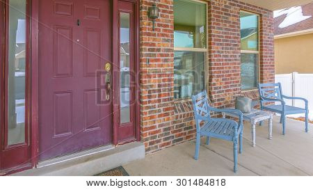 Clear Panorama Facade Of A Home With A Red Front Door And Reflective Sidelights And Windows