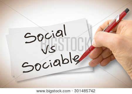 Hand Writing Social Vs Sociable With A Pencil On A Blank Sheet - Concept Image