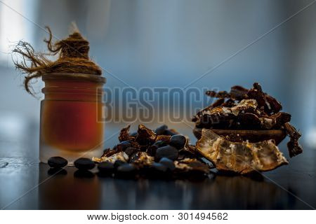 Raw Organic Amli Or Tamarind Or Imli In A Clay Bowl On Wooden Surface With Its Extracted Herbal Esse