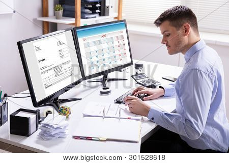 Businessman Calculating Invoice In Office