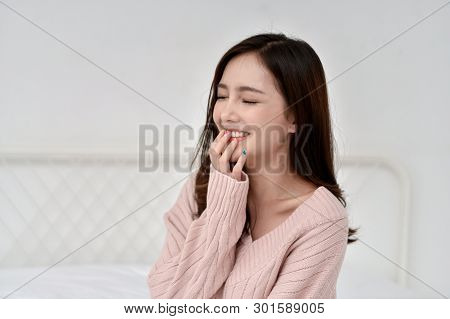 Relaxation Concept. The Beautiful Girl Is Smiling Happily Inside The Room. Beautiful Asian Girl Smil