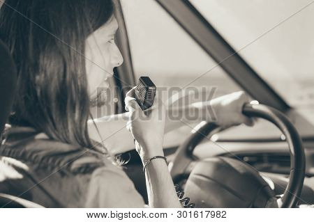 Talking While Drive, Auto Walkie Talkie, Comunication Concept. Young Man Driving Car Using Cb Radio.