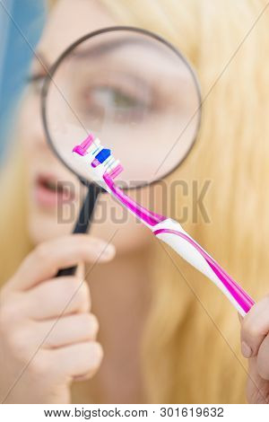 Beautiful Perfectionist Young Woman Checking Her Tooth Brush Through Manifying Loupe Glass. Hygiene,