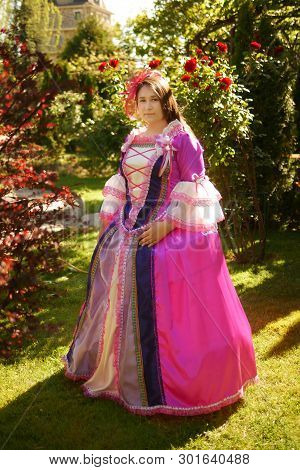 Girl Animator Dressed As A Medieval Princess On The Background Of The Castle In A Beautiful Park
