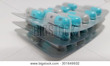 3 Sealed Packets Of Blue And Grey Tablets Stacked On Top Of Each Other.