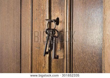 Old Rusty Keys Inside A Keyhole Of An Old Antique Closet. Vintage Design