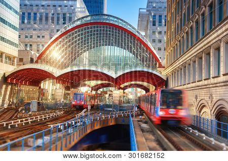 London, England - May 5, 2013: Canary Wharf, Dlr Station. Dlr Train Leaving The Station On A Bright 