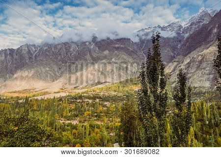 Nature Landscape View In Hunza Valley. Beautiful Scenery Of Green Forest With Clouds Covered Snow Ca