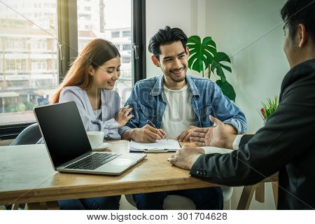 Sale Representative Present The Price And Conditon To Asian Young Couple When Signing The Contract H