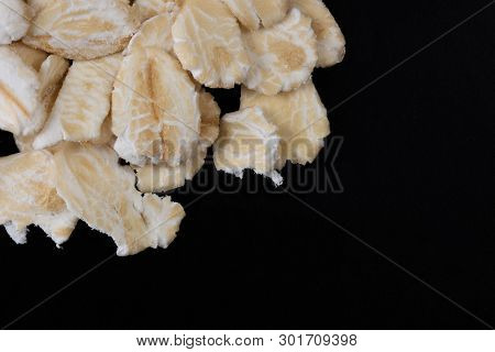 Macro Image Of Rolled Oats On A Black Background With Copy Space On The Bottom Right