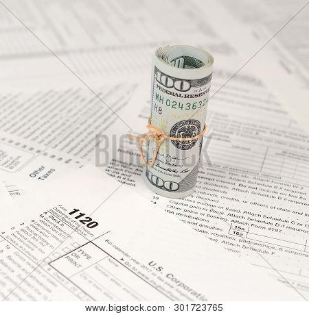 1120 U.s. Corporation Income Tax Return Form With Roll Of American Dollar Banknotes