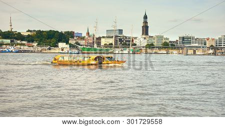 HaМburg, Germany- August 12, 2015: Boat With Tourists Goes On Elbe River In Hamburg With St. Michael