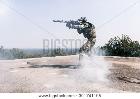 Armed Soldier With Rifle In Hand Aim At Enemies Standing On The Roof Of The Building