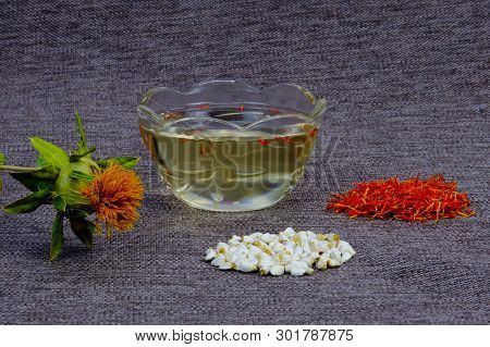 Safflower For Cosmetics And Spices To Food. Cosmetic Saffron Vegetable Oil In A Glass Cup, Flowers A