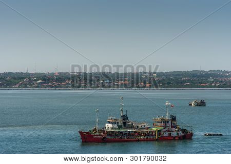 Bali, Indonesia - February 25, 2019: Port Of Benoa. 
Red Hartadika Oil Tanker Docked Along Fishing V