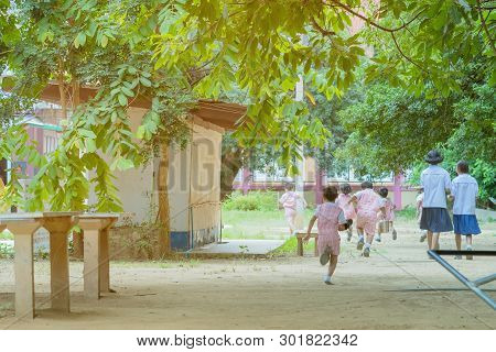 Back View Of Kindergarten Students Run Back To The Classroom After Having Lunch.