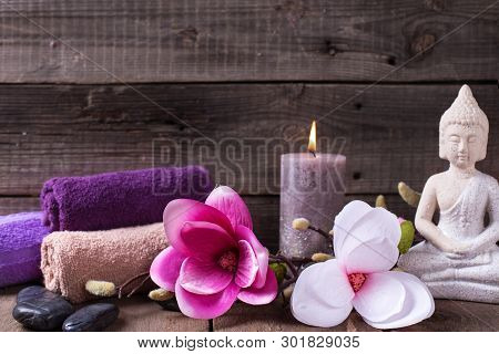 Set Of Towels For Spa, Burning Candle, Black Stones, Buddha And Pink  Flowers On  Rustic Textured Wo