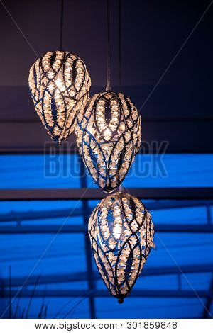 Seed Shaped Lampshades. Ornate Silver Lamps With Shiny Crystals In Darkness. Contemporary Chandelier