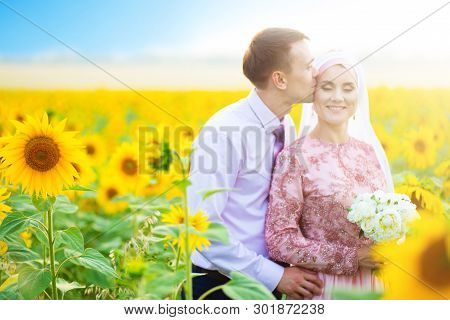 Smiling Young Islamic Couple Portrait On Sunflowers Field