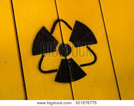 Radioactivity Sign, Close-up. Sign Of Radiation On A Yellow Wooden Board. Radioactive Sign - Symbol 