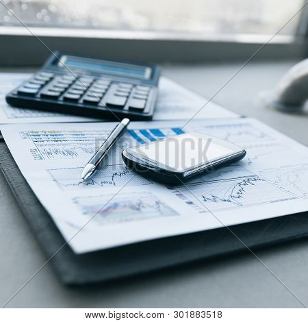 Calculator, Smartphone And Financial Documents On The Businessm