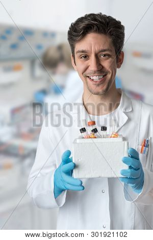 Smiling Male Scientist With Brown Eyes And Curly Hair Holds Box Of Samples