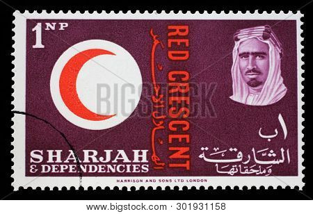 ZAGREB, CROATIA - JULY 03, 2014: A stamp issued in the Sharjah shows Red Crescent Emblem, portrait of Sheik Saqr bin Sultan al Qasimi, 100 years International Red Cross, circa 1963.