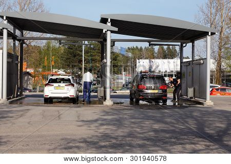 Orebro, Sweden - April 26, 2019: Two Taxis And Two Persons Washing Enviroment Friendly At The Self S
