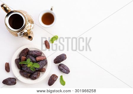 Ramadan Food And Drinks Concept. Ramadan Lantern With Tea, Dates Fruit, Grape And Mint Leaves On A W