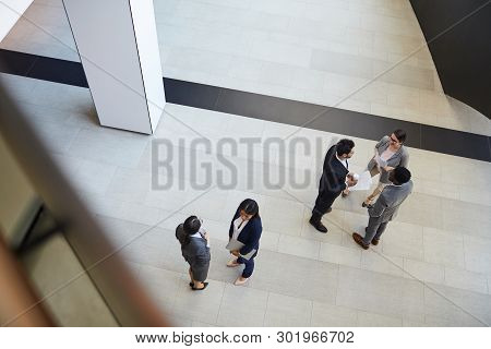 Directly Above View Of Intercultural Business People In Formal Outfits Standing In Groups In Lobby A