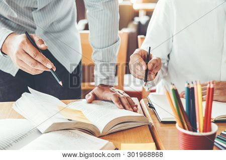 High School Or College Students Studying And Reading Together In Library