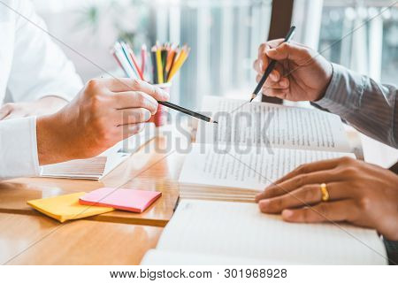 High School Or College Students Studying And Reading Together In Library