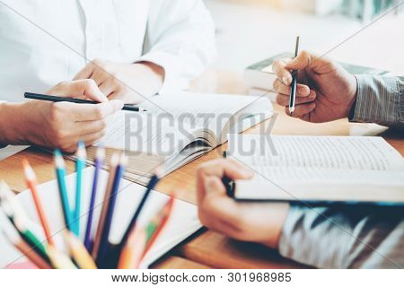 High School Or College Students Studying And Reading Together In Library