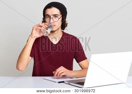 Close Up Portrait Of Attractive Man With Curly Hair Wears Black Hat, Spectacles, Watches Vebinar, Si