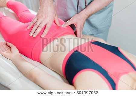 Close-up Of A Young Girls Spine Base Editing By A Male Physiotherapist Of Visceral Massage. The Hand