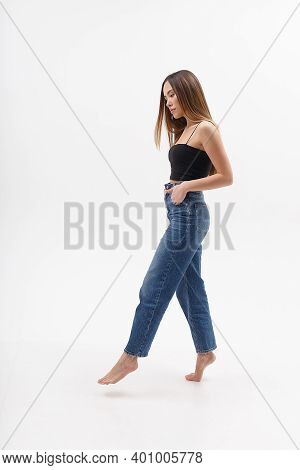 Young Attractive Asian Woman With Long Hair In Black Top, Blue Jeans Isolated On White Studio Backgr