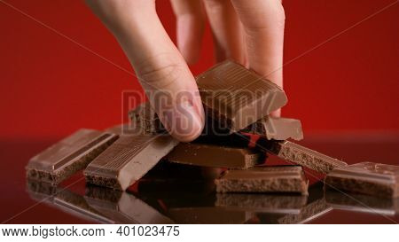Bunch Of Chocolate Pieces. Stock Footage. Close-up Of Hand Taking Piece Of Chocolate From Pile On Is