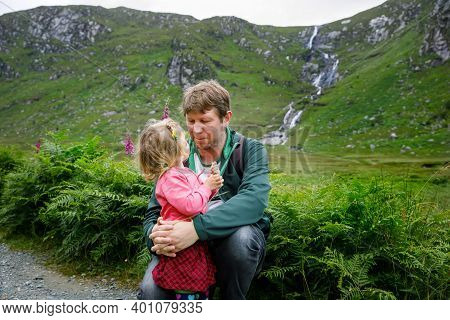 Little Happy Toddler Girl Hugging With Father In Glenveagh National Park In Ireland. Smiling And Lau