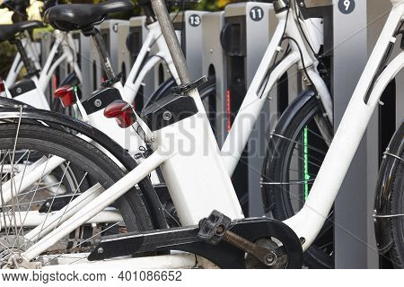 Urban Electric Bikes Charging Batteries In The City. To Rent