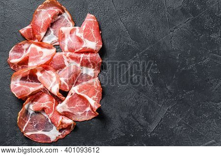 Italian Rolled Bacon Pancetta Piacentina. Pork Meat. Black Background. Top View. Copy Space
