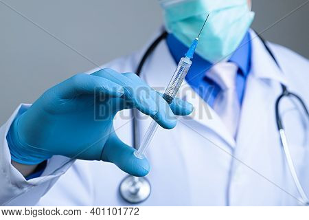 Close Up View Of Medical Syringe In Rubber Blue Glove Dressed Hand, Man Chest In White Medical Robe 