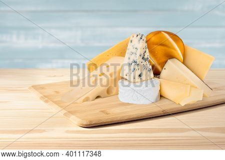 Composition Of Different Types Of Cheese On Wooden Background. Blue Cheese Dorblu, Smoked Suluguni, 