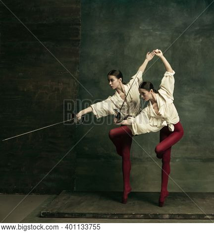 Passioned. Two Young Female Ballet Dancers Like Duelists With Swords On Dark Green Background. Cauca