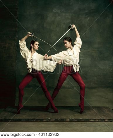 Passioned. Two Young Female Ballet Dancers Like Duelists With Swords On Dark Green Background. Cauca