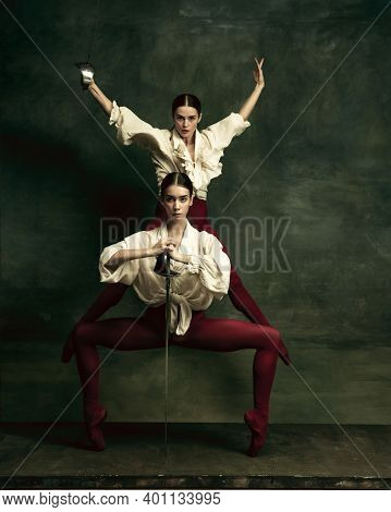 Feelings. Two Young Female Ballet Dancers Like Duelists With Swords On Dark Green Background. Caucas